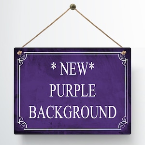 May include: A rectangular purple sign with white text that reads "*NEW* PURPLE BACKGROUND". The sign has a decorative white border and is suspended by a brown rope.