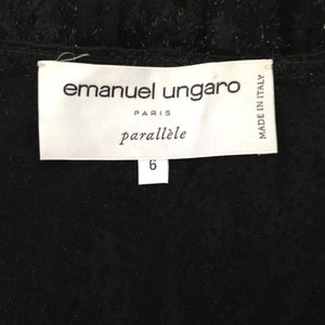 May include: A close-up of a black garment with a white label. The label reads "emanuel ungaro PARIS parall&egrave;le" with the number "6" below. The words "MADE IN ITALY" are also visible on the label.