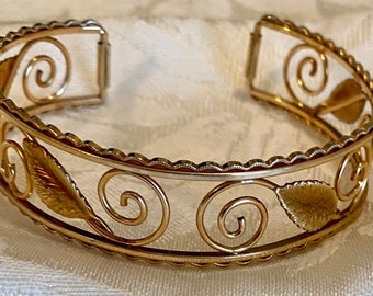 Vintage cuff bracelet signed Krementz, gold tone metal with leaves and spirals designs
