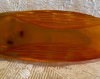 Vintage butterscotch bakelite clip with carved designs