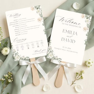 May include: Two rectangular wedding program fans with wooden handles and white satin ribbons. The cards feature floral illustrations, the text Welcome to the Wedding of Emilia and David, a wedding party list, and a ceremony timeline for March 14, 2026.