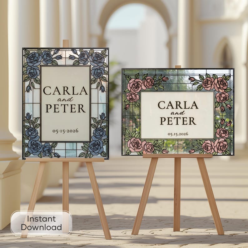 May include: Two rectangular wedding signs on wooden easels. The left sign features blue roses and the text CARLA and PETER 05.15.2026. The right sign features pink roses and the text CARLA and PETER 05.15.2026. Both signs have a stained glass border.