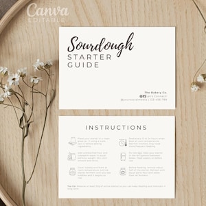 May include: A Sourdough Starter Guide card with instructions, set on a wooden tray with white flowers. The card features the text "Sourdough Starter Guide" in a stylish font, along with the bakery's contact information and instructions.