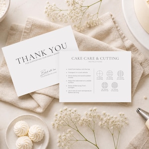 May include: A flat lay featuring baking supplies and a cake. Two white cards read "THANK YOU" and "CAKE CARE & CUTTING INSTRUCTIONS." Other items include a bowl of flour, butter, meringues, and a piping bag. The cake is decorated with white frosting.