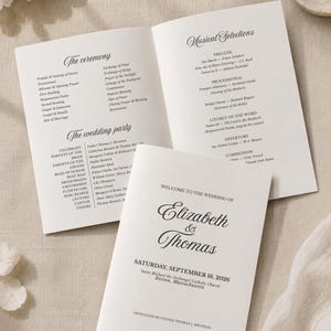 Könnte beinhalten: Ein weißes Hochzeitsheft mit schwarzem Text. Auf dem Umschlag steht Welcome to the Wedding of Elizabeth & Thomas, Saturday, September 16, 2026, Boston, Massachusetts. Das geöffnete Innere zeigt The Ceremony und Musical Selections.