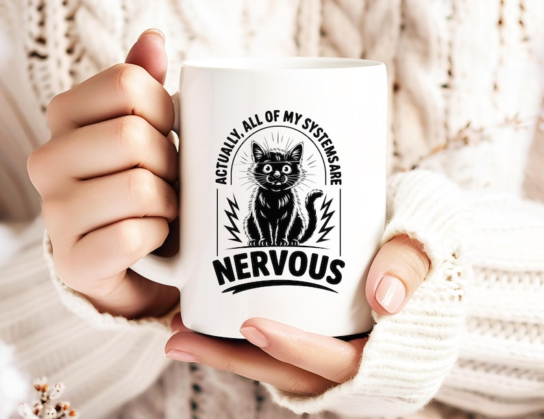 May include: White ceramic mug featuring a black cat illustration with the text "ACTUALLY, ALL OF MY SYSTEMS ARE NERVOUS". The cat has wide eyes and a nervous expression. The mug has a curved handle.