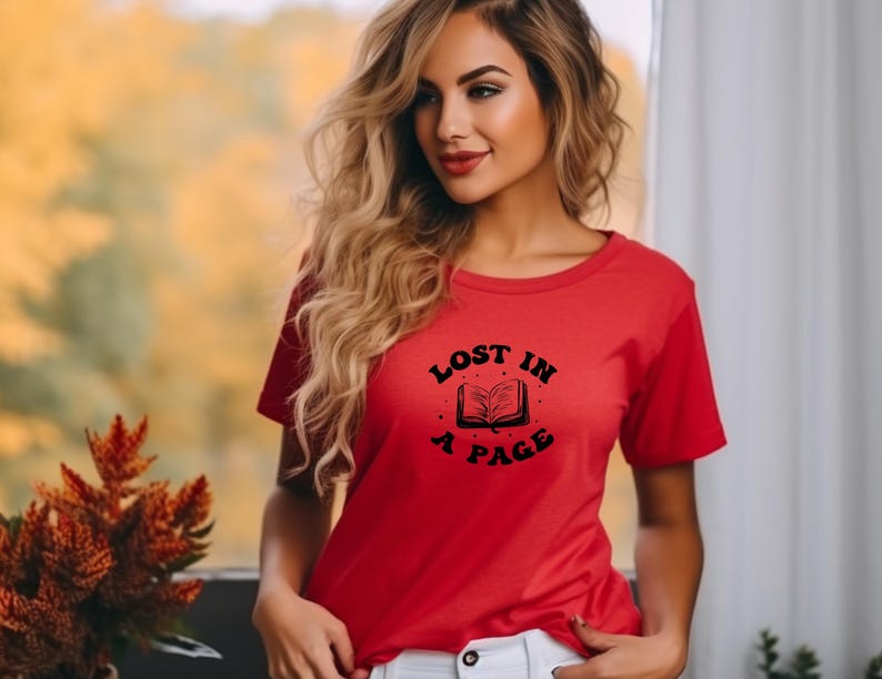 May include: Red t-shirt with a black graphic of a book and the text "Lost in a Page".