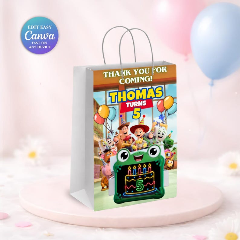 May include: A white paper gift bag featuring a colourful graphic of Toy Story characters, balloons, and a green frog-shaped frame displaying a birthday cake with the number 5. The text reads THANK YOU FOR COMING! THOMAS TURNS 5.