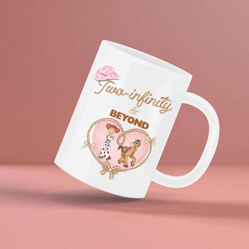 Peut inclure: Mug en c&eacute;ramique blanche avec un motif en forme de c&oelig;ur repr&eacute;sentant une cowgirl de dessin anim&eacute; et un cheval. Le mug porte l'inscription "Two-infinity & Beyond" dans une police d&eacute;corative, avec un chapeau de cow-boy rose.