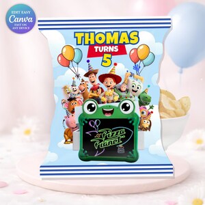 May include: A personalised chip bag design for a birthday celebration. The bag displays the text "THOMAS TURNS 5" with Toy Story characters and balloons. A green frog-shaped sign reads "Pizza Planet". The bag is blue with white stripes.