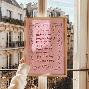 May include: A framed pink print with the text "if scrolling actors' imdb pages, trying to figure out what I know them from was a job, I'd be a millionaire." The frame is gold-coloured.