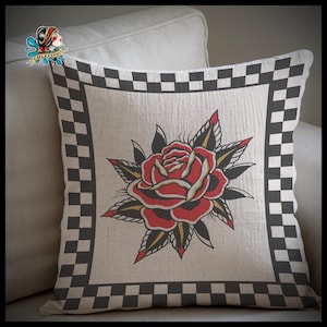 May include: A decorative cushion with a black and white chequered border. The centre of the cushion features a traditional tattoo style red rose with black and yellow outlines.