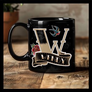 May include: Black ceramic mug with a tattoo-style design featuring a large gold letter "W" with a red rose, a blue swallow, and a banner reading "WENDY".