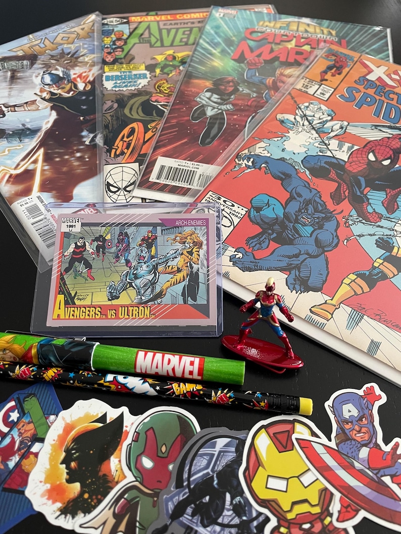 May include: A collection of Marvel comic books featuring characters like Captain Marvel, Thor, and Spider-Man. There is also a trading card featuring the Avengers vs Ultron, a pencil with the Marvel logo, and several stickers with Marvel characters.