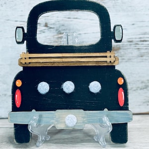 May include: Black wooden truck cutout with a white felt bumper and three white felt circles on the back. The truck has a wooden bed and a gray painted bumper.