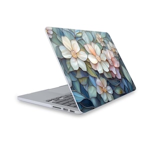 May include: A laptop computer with a floral design on the lid. The design features white flowers with pink and blue accents on a blue background.