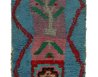 May include: A colorful Moroccan rug with a geometric pattern in shades of blue, red, green, and pink. The rug has a fringed edge and is made of wool.