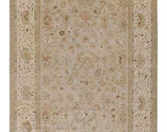May include: Rectangular beige area rug with an intricate floral pattern. The rug features a central field with a detailed design and a border with floral and geometric elements. The color palette includes beige, brown, and touches of green.