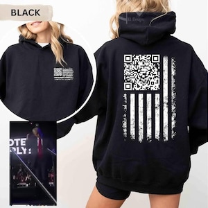 May include: Black hoodie with a distressed American flag design on the back, featuring a QR code in the stars section. The front of the hoodie has a smaller flag design. The word "BLACK" is displayed at the top.