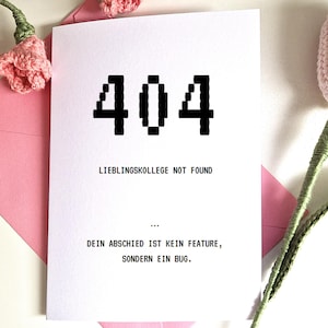 Op de afbeelding: Een witte kaart met het nummer "404" in pixelachtige zwarte letters. De kaart luidt "LIEBLINGSKOLLEGE NOT FOUND" en "DEIN ABSCHIED IST KEIN FEATURE, SONDERN EIN BUG." De kaart zit in een roze envelop, met roze gehaakte bloemen.