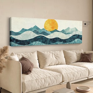 Könnte beinhalten: Ein langes, rechteckiges Wandbild auf Leinwand mit einer stilisierten Landschaft aus geschichteten Gebirgszügen in Blaugrün, Dunkelblau und Weiß, gekrönt von einer großen, texturierten goldgelben Sonne vor einem cremefarbenen Himmel.