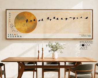 May include: A rectangular framed wall art print featuring a large golden sun on a beige background with a flock of black birds flying across. The text reads YAYOI KUSAMA, the Japanese characters for dance of colors, and JAPAN 1986.