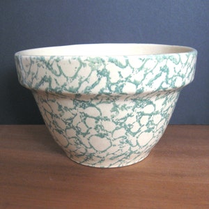 May include: A green and white ceramic mixing bowl with a mottled glaze pattern.