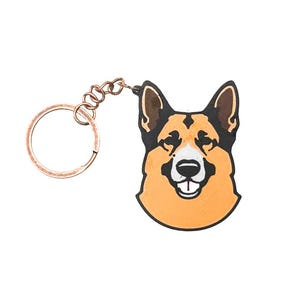 May include: A brown and black German Shepherd dog keychain with a gold-colored key ring.