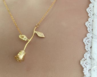 Peut inclure: Un collier en or en forme de rose avec une chaîne délicate et un pendentif rose détaillé.