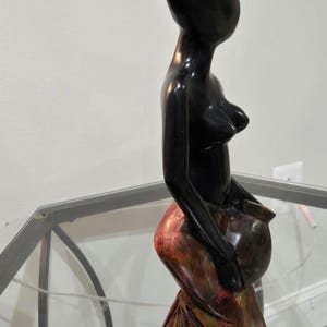 Handskuren afrikansk träskulptur av en kvinnlig figur som bär ett fartyg Ghana konst afrocentrisk