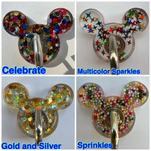 May include: Four resin wall hooks shaped like mouse heads. Top left: Celebrate with multicolored hexagonal glitter. Top right: Multicolor Sparkles with star-shaped glitter. Bottom left: Gold and Silver with metallic flakes. Bottom right: Sprinkles with small colorful spheres.