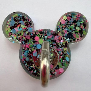 May include: A clear resin wall hook shaped like a mouse head, filled with a dense mix of multicolored hexagonal and fine glitter in shades of neon pink, bright blue, lime green, and black, featuring a central silver-toned metal hook.