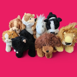 Op de afbeelding: Een verzameling pluche dieren, waaronder een hond, een eekhoorn, een paard, een koe en een leeuw, tegen een helder roze achtergrond. De knuffels zijn zacht, kleurrijk en hebben gedetailleerde kenmerken.