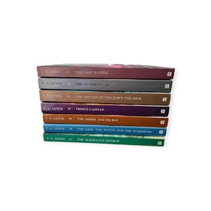 Peut inclure: Une pile de sept livres de C.S. Lewis, dont "The Last Battle", "The Silver Chair" et "Prince Caspian". Les dos des livres sont de couleurs variées, avec des titres imprimés en blanc. Les livres sont empilés sur fond blanc.