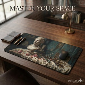 May include: A rectangular desk mat featuring a classical sculpture bust, roses, and the text "MASTER YOUR SPACE." The mat has a dark background with a teal and cream color scheme. A black computer mouse is on the mat.