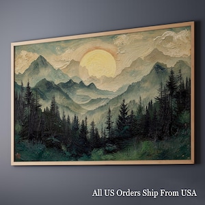 May include: A framed landscape painting depicts a mountain range with a large yellow sun setting behind the peaks. Dark green trees fill the foreground, with a light brown frame. The painting has a textured, impasto style.