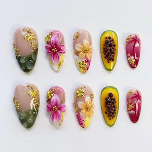 May include: A collection of ten artificial nails with diverse designs. Some nails showcase 3D flowers, gold accents, and a papaya design. Other nails feature a palm tree design with gold accents. The nails are in shades of pink, yellow, and green.
