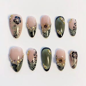 Puede incluir: Un conjunto de diez uñas artificiales con diversos diseños. Las uñas presentan una combinación de colores, incluyendo rosa, verde oliva y negro, con motivos florales y de estampado animal. Algunas uñas están adornadas con pedrería.