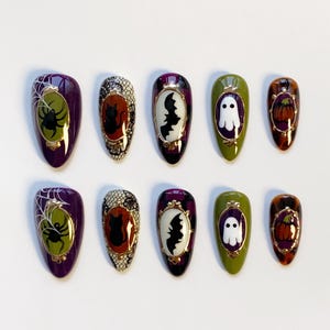 May include: A set of ten press-on nails with Halloween-themed designs. Each nail features a different design, including a spider, cat, bat, ghost, and pumpkin. The nails are oval-shaped and painted in various colors, including purple, green, and orange.