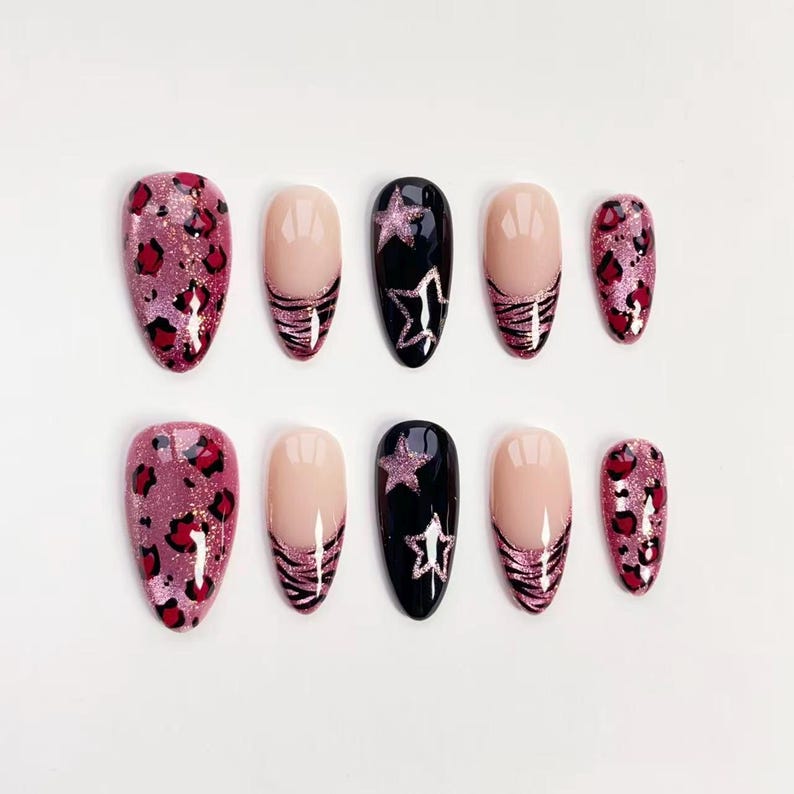 Puede incluir: Un conjunto de diez u&ntilde;as postizas con varios dise&ntilde;os. Algunas u&ntilde;as presentan un estampado de leopardo rosa, otras tienen una base nude con una raya de cebra rosa brillante, y algunas son negras con un dise&ntilde;o de estrella brillante.