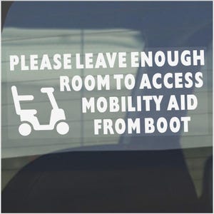May include: White sticker with black text that reads "Please leave enough room to access mobility aid from boot". A white silhouette of a mobility scooter is to the left of the text.