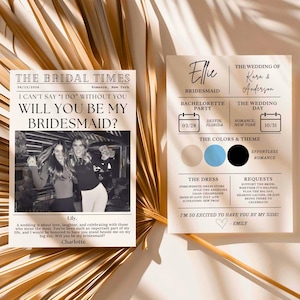以下が含まれることがあります： 新聞風のデザインのブライズメイドプロポーズカード。カードには2人の女性の画像、日付の入ったカレンダー、そして「私のブライズメイドになってくれますか？」というテキストが書かれています。