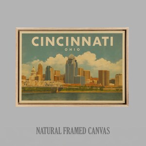 May include: A framed canvas print depicting a vintage illustration of Cincinnati, Ohio. The artwork shows the city's skyline, a bridge, and the text "Cincinnati Ohio". The canvas is in a natural wood frame.