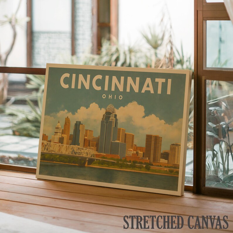 May include: A canvas print depicting the Cincinnati, Ohio skyline. The artwork shows the city's buildings, a bridge, and the Ohio River under a blue sky with clouds. The word "CINCINNATI" is printed at the top, with "OHIO" below it.