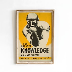 May include: Framed vintage poster with a yellow background and a black and white illustration of a muscular man in a thinking pose. The poster reads "FOR GREATER KNOWLEDGE ON MORE SUBJECTS USE YOUR LIBRARY OFTEN!"