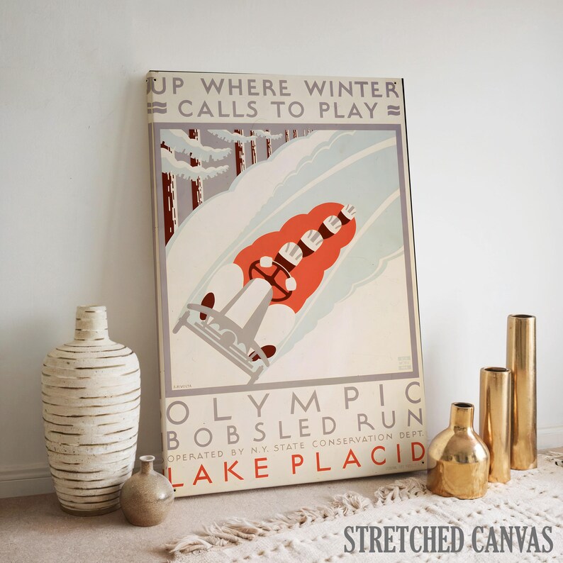 May include: A vintage-style stretched canvas print featuring a bobsled run scene. The artwork showcases a red bobsled with a driver and passengers racing down a snowy track, with text that reads "UP WHERE WINTER CALLS TO PLAY" and "OLYMPIC BOBSLED RUN LAKE PLACID".
