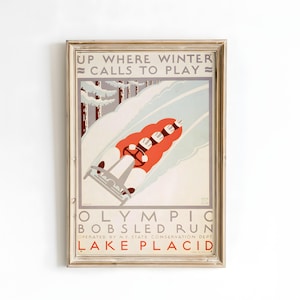 May include: Vintage framed poster advertising the Olympic Bobsled Run at Lake Placid. The poster features a red bobsled with four figures racing down a snowy track, with text that reads "Up Where Winter Calls to Play".