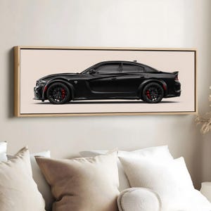May include: A framed print featuring a black Dodge Charger sedan. The car is shown in profile, with black wheels and red brake calipers. The artwork is set against a neutral background and framed in a light wood.