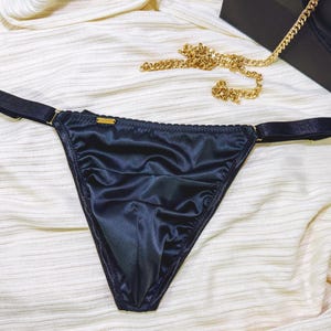 Puede incluir: Lencería de satén negro con tirantes ajustables.