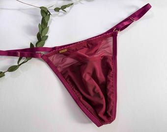 Op de afbeelding: Bordeauxkleurige kantenlingerie met een gouden label met de tekst "Secret".